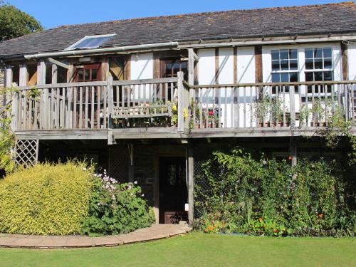 a house with a wooden deck and a porch at The Barn in Dartmouth