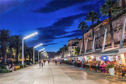 a city street at night with people and restaurants at Tamaria in Split