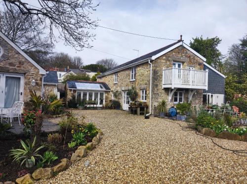 uma casa com uma entrada de cascalho em frente em Pleasant streams Barn em St Austell