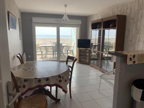 une cuisine et une salle à manger avec une table et un balcon dans l'établissement Appartement T2 neuf avec parking à Fort-Mahon-Plage - FR-1-482-77, à Fort-Mahon-Plage
