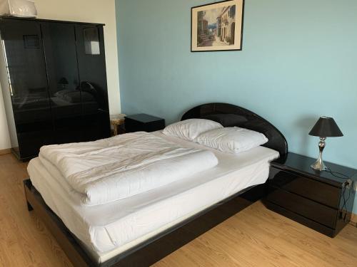 a bed in a room with a nightstand and a bed sidx sidx at Appartement T2 neuf avec parking à Fort-Mahon-Plage - FR-1-482-77 in Fort-Mahon-Plage