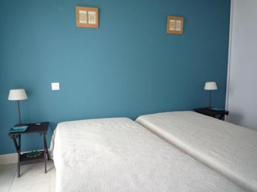une chambre avec un lit et un mur bleu dans l'établissement Charmant T2 avec Balcon, Parking et Accès Plage - Les Sables d'Olonne - FR-1-325-110, à Les Sables-dʼOlonne