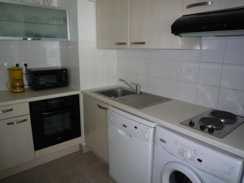 une cuisine blanche avec un évier et un lave-vaisselle dans l'établissement Charmant T2 avec Balcon, Parking et Accès Plage - Les Sables d'Olonne - FR-1-325-110, à Les Sables-dʼOlonne