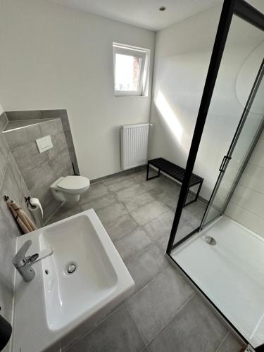 a white bathroom with a sink and a toilet at Zimmervermietung Altes Zollhaus in Obernkirchen