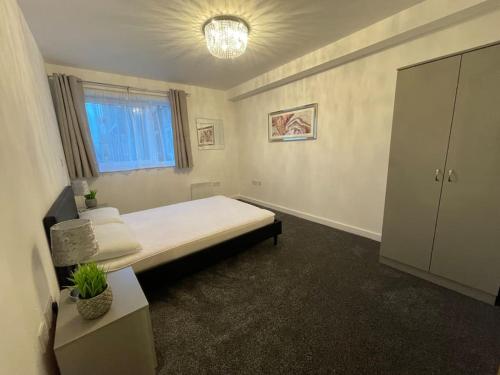 a bedroom with a large bed and a window at Moda Wigan 2 - Stylish 2 Bed in Central Wigan in Wigan