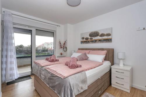 una camera da letto con un grande letto con lenzuola rosa di Luxury Apartment Isabell a Zaton