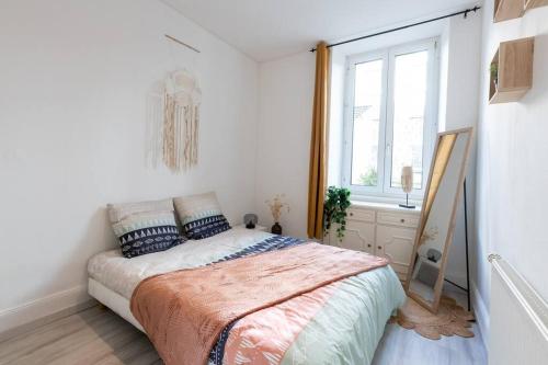 1 dormitorio con cama y ventana en Appartement entièrement rénové et cosy avec jardin, en Mulhouse