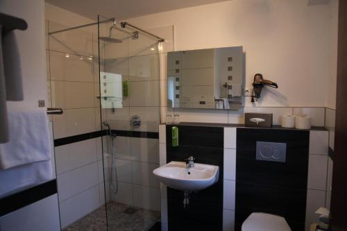 a bathroom with a sink and a shower at Hotel Diana Garni in Malente