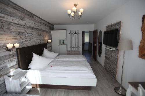 a bedroom with a white bed and a brick wall at Hotel Diana Garni in Malente