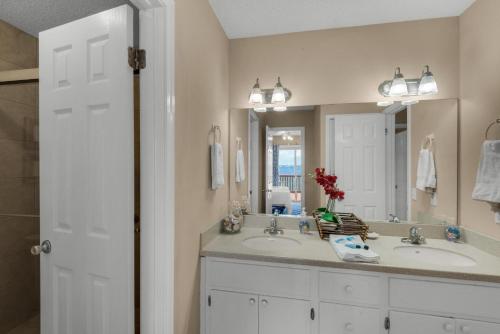 baño con 2 lavabos y espejo grande en Le Starboard House en Pensacola Beach