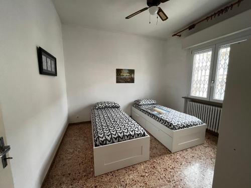 Habitación con 2 camas y ventilador de techo. en Casa Vacanze Dalla Lory en Rímini