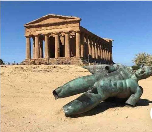 a statue of a woman laying on the ground in front of a building at Appartamento il sole 2 piano in Realmonte