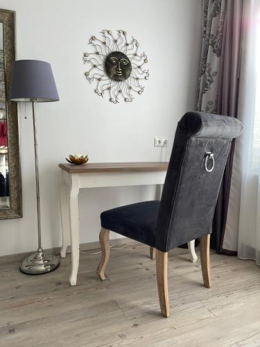 a chair sitting in front of a desk with a lamp at Hotel Diana Garni in Malente