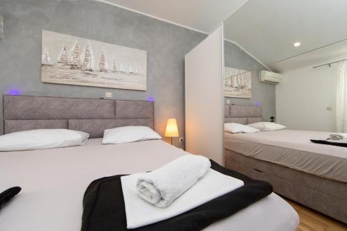 a bedroom with two beds with white towels on them at Villa Fina in Tučepi
