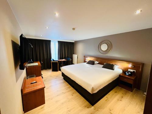 een hotelkamer met een groot bed en een tafel bij Hotel Melba in Bastenaken