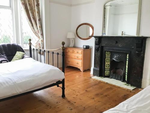 a bedroom with a bed and a fireplace at Sandancer in South Shields