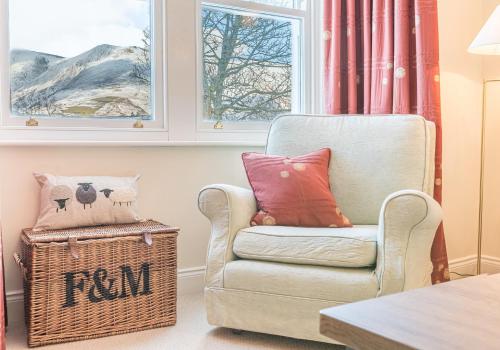 a living room with a chair and a window at 7 Greta Grove House in Keswick