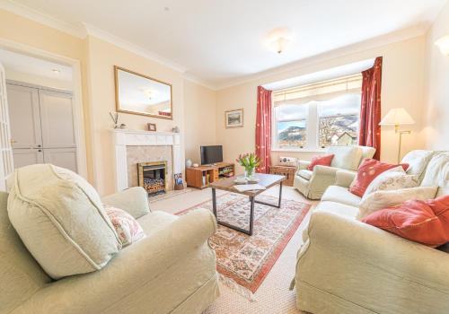 a living room with two couches and a fireplace at 7 Greta Grove House in Keswick