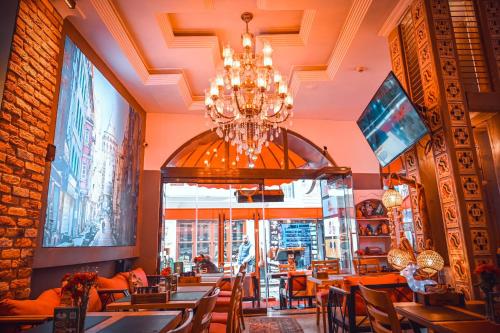 a restaurant with a chandelier and tables and chairs at Ethnica Hotel Old City in Istanbul