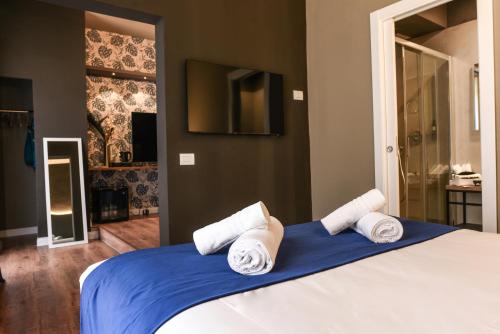 1 dormitorio con 1 cama con toallas en Il Corso Comfort Rooms, en Roma