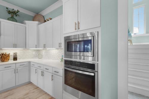 a kitchen with white cabinets and a stainless steel oven at Dream Maker in Navarre
