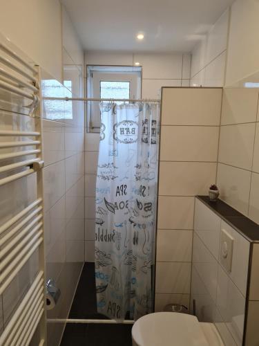 a bathroom with a toilet and a shower curtain at Erdgeschosswohnung in Marl in Marl