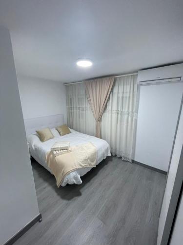 Habitación pequeña con cama y ventana en Tu precioso piso en el centro de Torrejón, en Torrejón de Ardoz