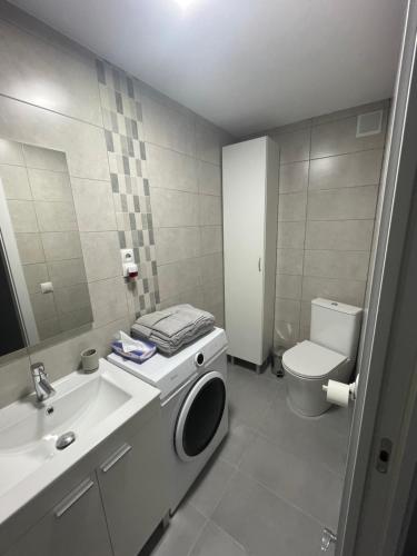 een badkamer met een wastafel en een wasmachine bij Tu precioso piso en el centro de Torrejón in Torrejón de Ardoz