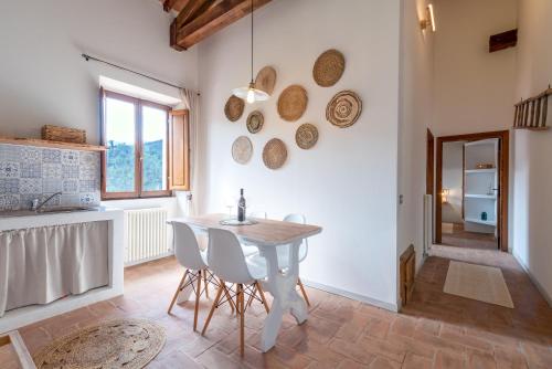 cocina con mesa y sillas en una habitación en Gea - In Parulia Country House, en Arezzo
