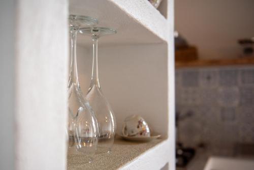 deux verres à vin assis sur une étagère dans une cuisine dans l'établissement Gea - In Parulia Country House, à Arezzo