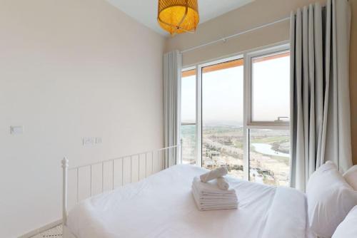 a bedroom with a bed and a large window at Key View - Golf Vita in Dubai Marina