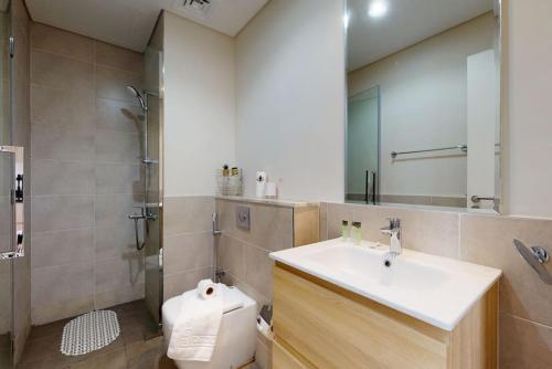 a bathroom with a sink and a toilet and a mirror at Key View - Golf Vita in Dubai Marina