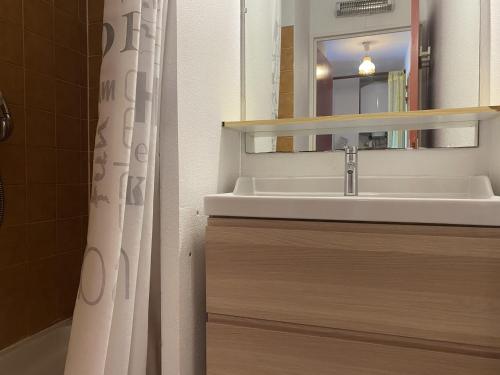 une salle de bain avec un lavabo et un rideau de douche dans l'établissement Studio cabine avec loggia vitrée proche plage et commerces à Sète - FR-1-338-406, à Sète