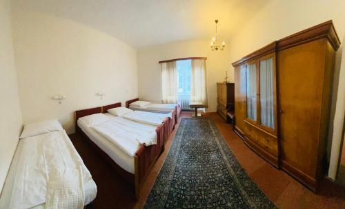 1 dormitorio con 3 camas y ventana en EA Hotel Hrubá Skála en Hrubá Skála