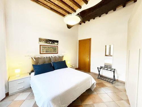 een slaapkamer met een groot wit bed met blauwe kussens bij Casa Montanini Centro Storico in Siena