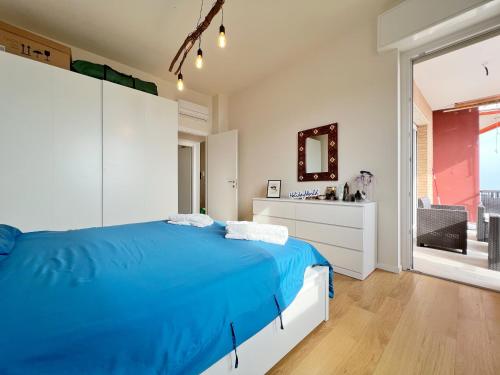 a bedroom with a blue bed and a bathroom at Seaside Luxury Apartment by Holiday World in Cogoleto