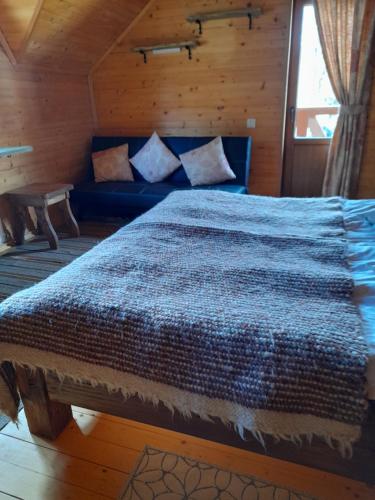 a bedroom with a blue bed and a blue couch at Na Penkah in Yaremche
