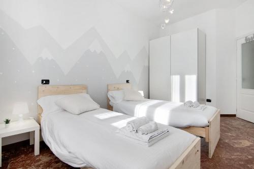 2 camas en una habitación con paredes blancas en Casa Glicine, en Domaso