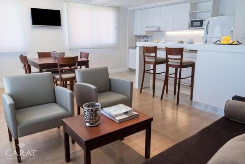 a living room with a couch and a table with chairs at Hotel Carat Apart Boutique in Rosario