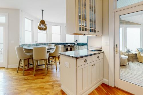 a kitchen with white cabinets and a table with chairs at Barn at the Beach - Main House in Georgetown
