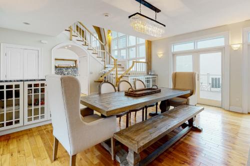 a dining room with a table and chairs and a staircase at Barn at the Beach - Main House in Georgetown