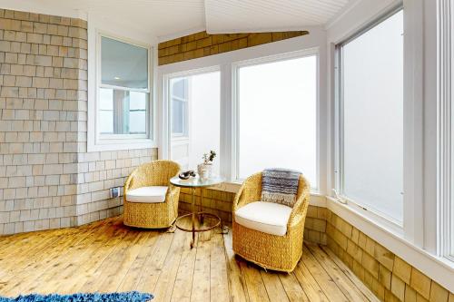 two chairs and a table in a room with windows at Barn at the Beach - Main House in Georgetown