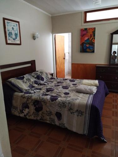 a bedroom with a bed with a blanket on it at Homestay Iquique in Iquique