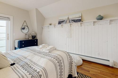 a bedroom with a large bed with a white wall at Barn at the Beach - Main House in Georgetown
