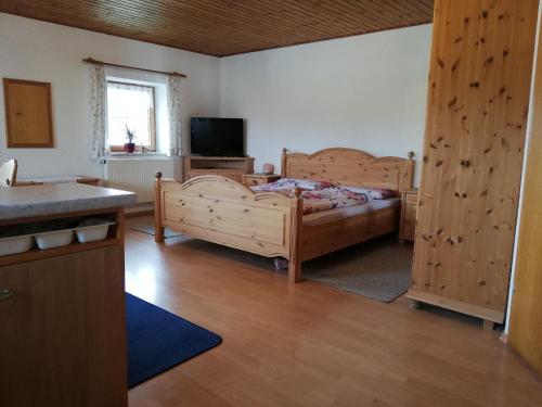 a bedroom with two wooden beds and a television at Ferienapartment Brandstatt in Seeg