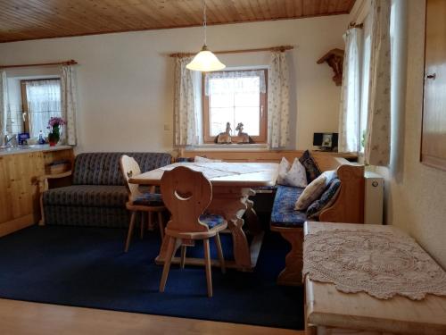 a living room with a table and chairs and a couch at Ferienapartment Brandstatt in Seeg