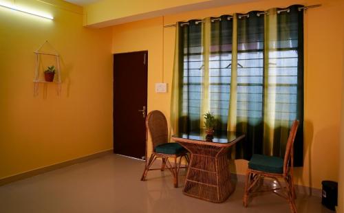 a dining room with a table and chairs and a window at Yellow Sapphire, Premium Sikkimese Homestay in Gangtok