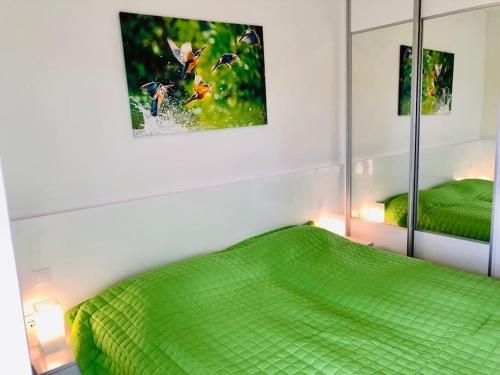 ein Schlafzimmer mit einem grünen Bett und zwei Spiegeln in der Unterkunft Admiral Lakeside Luxury Apartment in Siófok