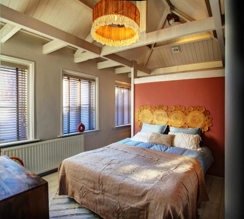 Villa Azura في ثولين: غرفة نوم بسرير كبير وبجدار احمر