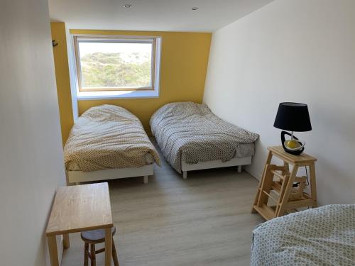 une chambre avec deux lits et une fenêtre dans l'établissement Fort-Mahon-Plage: Duplex 2 chambres, parking, balcon, plage à proximité - FR-1-482-86, à Fort-Mahon-Plage
